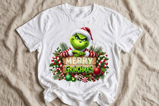 Бяла тениска с Grinch подпрян на дървена табела Merry Grinchmas с бонбони и коледни топки